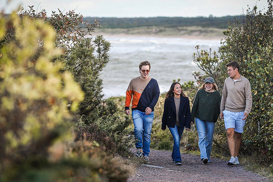 A group of students walking in the nature by the beach. Photo.