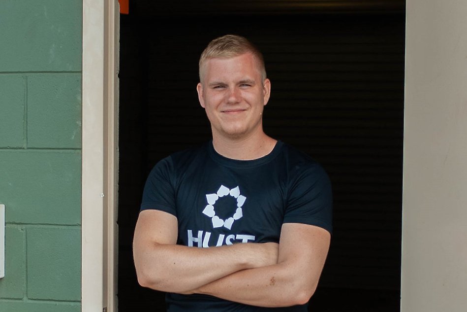 Young man standing in a door opening with his arms crossed. Photo.